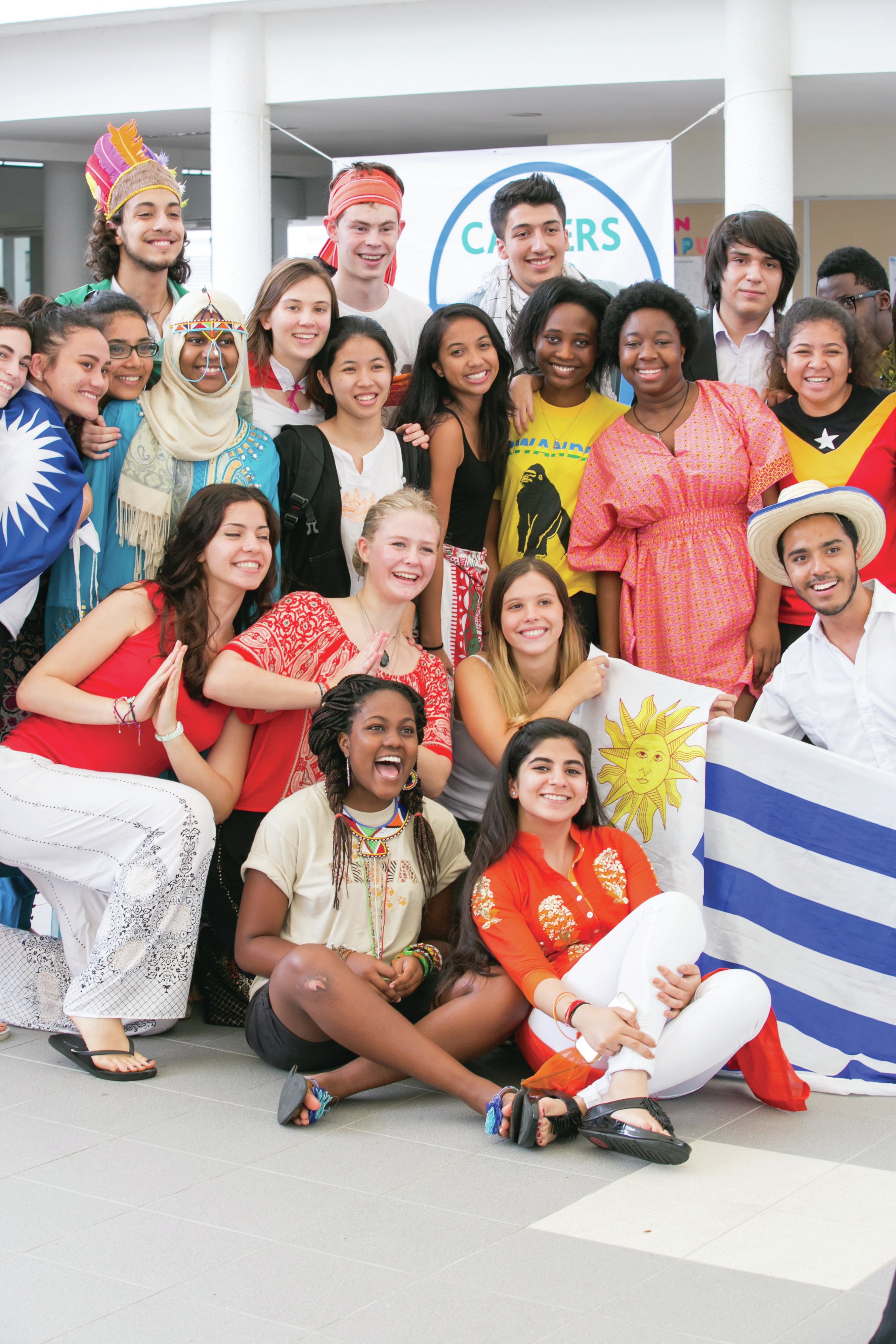 A group of students is posing with flags